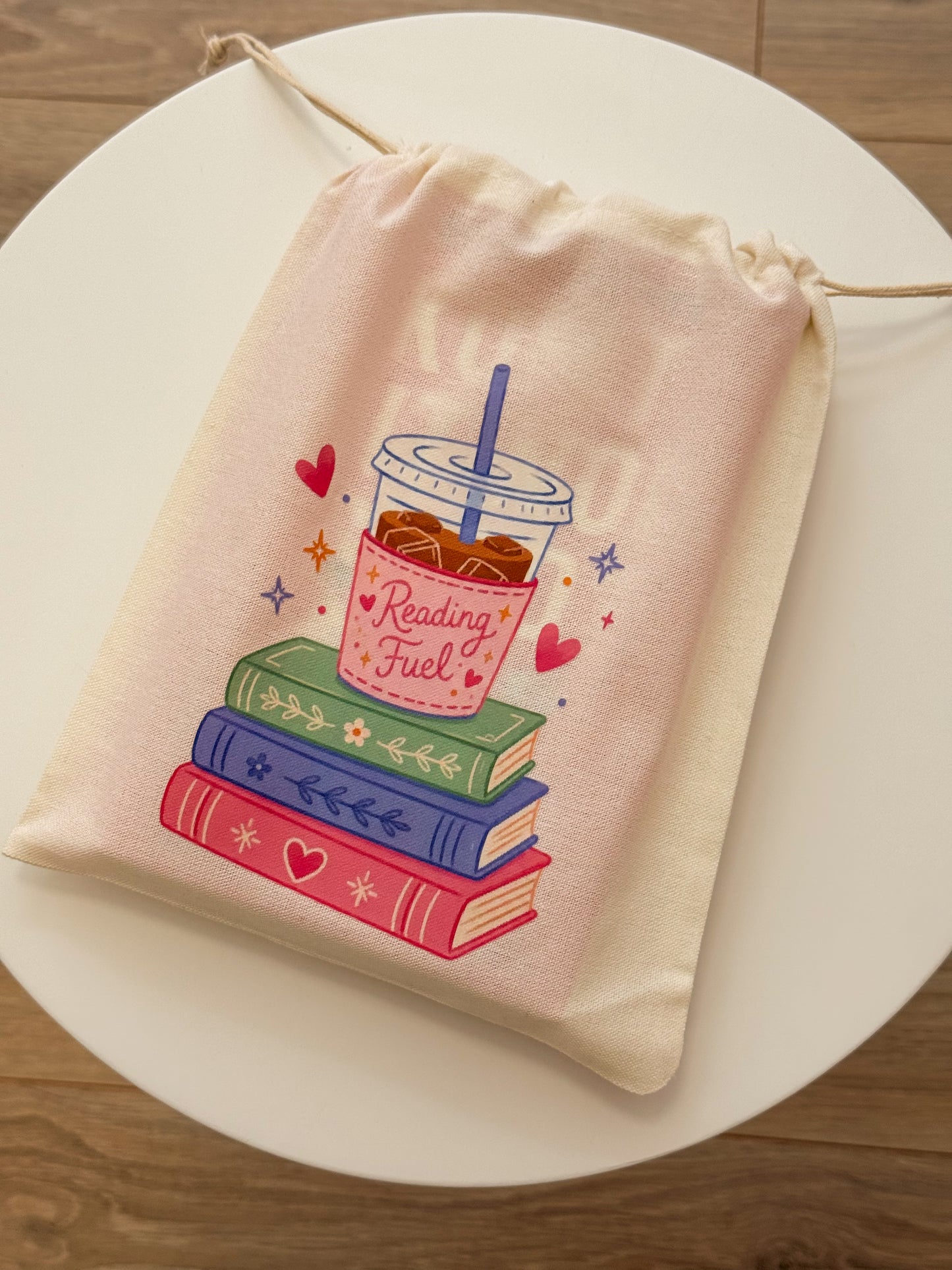 Book pouch Reading Fuel met ijskoffie en stapel boeken.