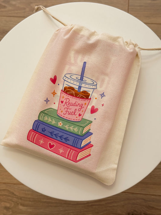 Book pouch Reading Fuel met ijskoffie en stapel boeken.