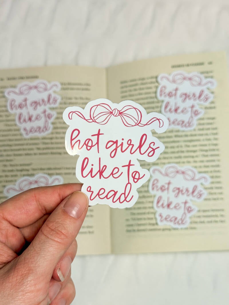 Boekenliefhebbers sticker met de tekst 'Hot girls like to read' in speelse roze letters met een strik erboven, ideaal voor bookish decoratie.